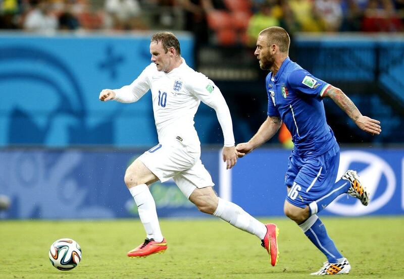 Wayne Rooney dribbles away from Daniele De Rossi during England and Italy's 2014 World Cup Group D match on Saturday in Manaus, Brazil. Jeon Heon-Kyun / EPA