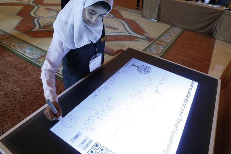 AlReem Rashid Ahmed uses a digital pad at the Mohammed Bin Rashid Smart Learning Programme awards ceremony in Dubai. The tablet computer technology converts a user’s handwriting into a test that can be stored electronically for later use or for e-mails. Antonie Robertson / The National