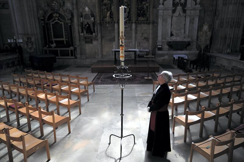 YORK, ENGLAND - MAY 14: Canon Maggie McLean, the Canon Missioner at York Minster, lights the Paschal Candle, a Christian symbol of Christ rising from the empty tomb on the first Easter Day, in York Minster's Lady Chapel on May 14, 2020 in York, England. Following an announcement by the House of Bishops last week, clergy can now re-enter churches and cathedrals to pray, which had been precluded under Covid-19 lockdown measures. York Minster have launched a new initiative for worshipers to email a request for their loved one to be remembered in a prayer that will be said by clergy at the Paschal Candle. The Paschal Candle would normally have burned continually throughout the Easter season until the Feast of Pentecost, 50 days later. (Photo by Ian Forsyth/Getty Images)