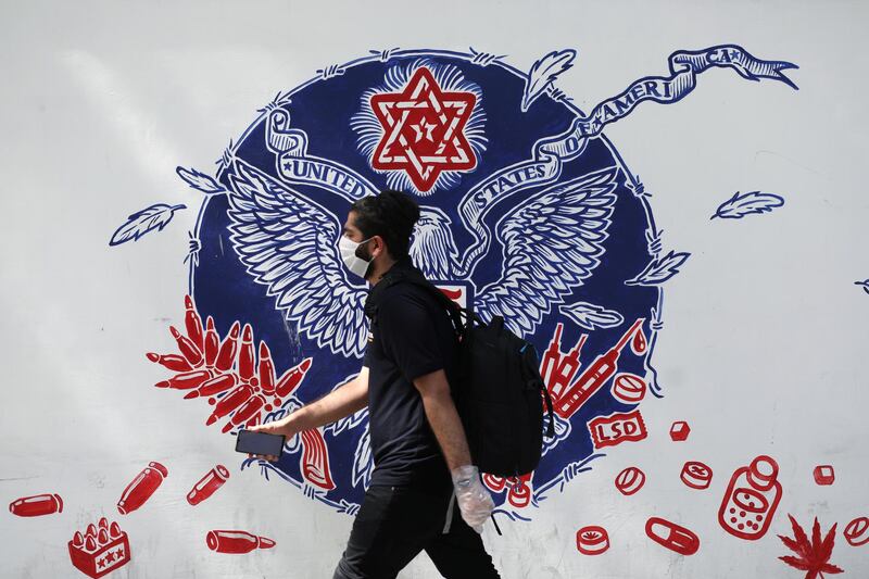 An Iranian man wearing a protective mask walks past a wall of a former U.S Embassy, following the outbreak of the coronavirus disease (COVID-19), in Tehran, Iran, June 28, 2020. WANA (West Asia News Agency) via REUTERS ATTENTION EDITORS - THIS PICTURE WAS PROVIDED BY A THIRD PARTY