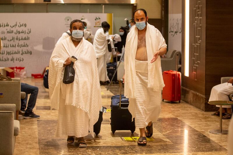 Muslim pilgrims pull their luggage as they wear protective masks heading to the Meeqaat. REUTERS