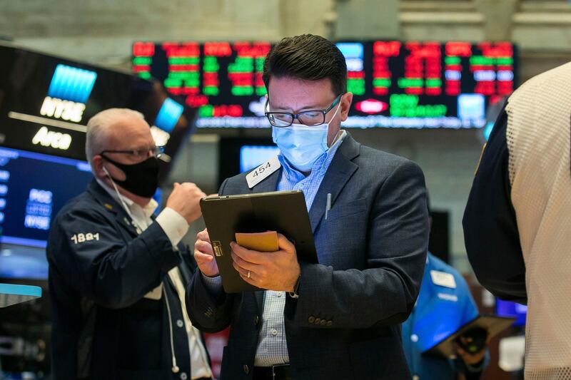 In this photo provided by the New York Stock Exchange, trader Americo Brunetti, center, works on the floor, Tuesday, Feb. 9, 2021. Stocks were slightly lower in early trading on Tuesday, after the major stock market indexes hit record highs the day before. Investors continue to keep their eyes on Washington, where it appears Democrats plan to move ahead without Republican help on a major stimulus bill for the economy. (Courtney Crow/New York Stock Exchange via AP)