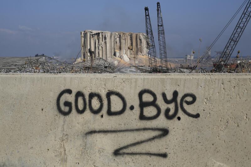 BEIRUT, LEBANON - AUGUST 05: A graffitied wall reading "goodbye" pictured in front of the smoldering buildings in the city's port, destroyed by an explosion a day earlier, on August 5, 2020 in Beirut, Lebanon. As of Wednesday morning, more than 100 people were confirmed dead, with thousands injured, when an explosion rocked the Lebanese capital. Officials said a waterfront warehouse storing explosive materials, reportedly 2,700 tons of ammonium nitrate, was the cause of the blast. (Photo by Marwan Tahtah/Getty Images)