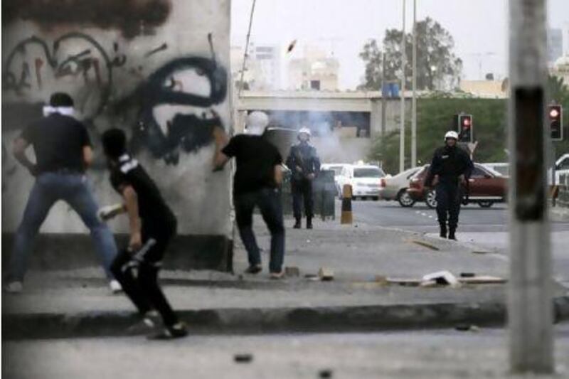 Anti-government protesters clash with riot police during protests Thursday outside Manama in Bahrain.