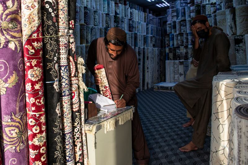 A carpet seller makes his first sale of the week.
