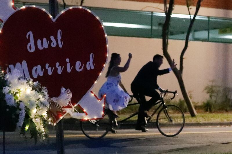 Lane and Christine Abraben depart their drive-thru wedding ceremony on a bicycle built for two after they were married at the Family and Civil courthouse in Gainesville, Florida. AP