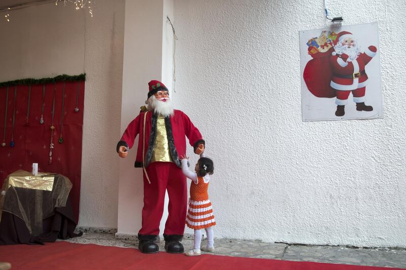 A small Christian Palestinian girl as she plays with a mechanical Santa Claus at the YMC in Gaza City on December 22,2018. (Photo by Heidi Levine for The National).