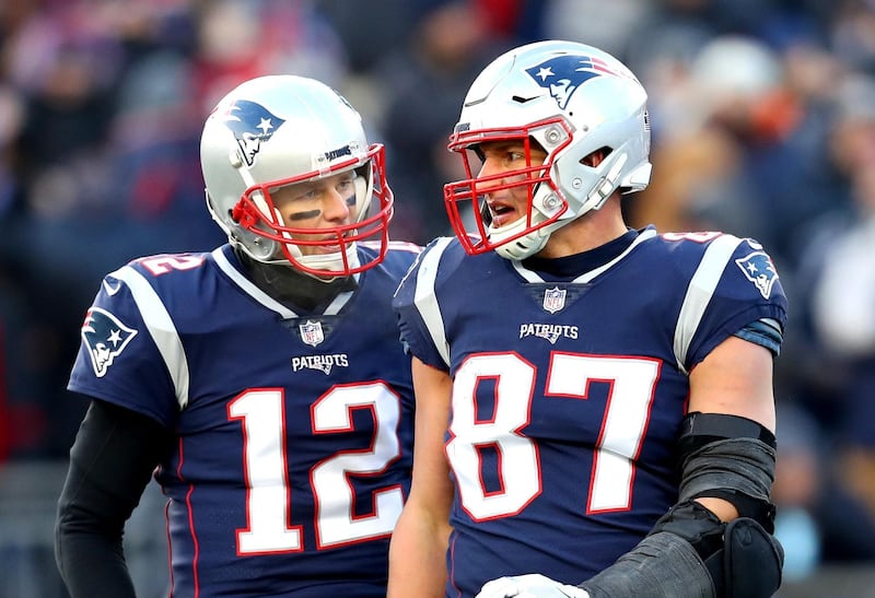 (FILES) In this file photo Tom Brady #12 of the New England Patriots reacts with Rob Gronkowski #87 during the third quarter in the AFC Divisional Playoff Game against the Los Angeles Chargers at Gillette Stadium on January 13, 2019 in Foxborough, Massachusetts. Rob Gronkowski said on APril 22, he had hinted at the possibility of reuniting with Tom Brady months before his shock decision to come out of retirement and follow the six-time Super Bowl champion to the Tampa Bay Buccaneers. / AFP / GETTY IMAGES NORTH AMERICA / Maddie Meyer
