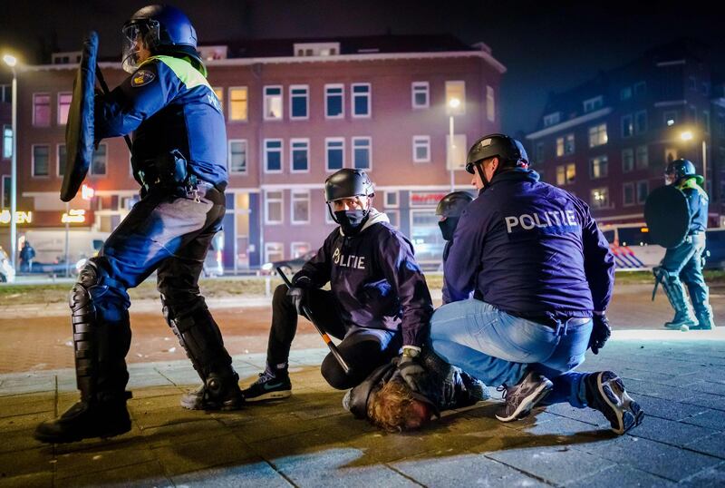 Dutch policemen arrest a man during clashes in Rotterdam. AFP