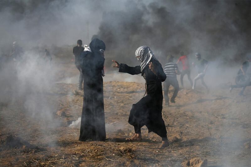 Palestinian women react to tear gas fired by Israeli troops during a protest at the Israel-Gaza border in the southern Gaza Strip on July 13, 2018. Reuters