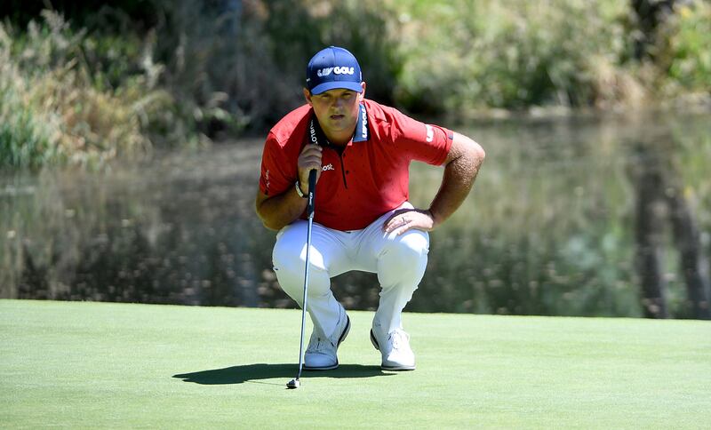 Patrick Reed lines up his putt on the third hole. AFP