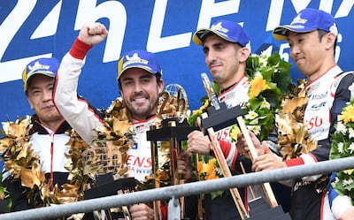 TOPSHOT - Toyota TS050 Hybrid LMP1 of Japanese's driver Kazuki Nakajima (R) Spain's driver Fernando Alonso (2L) and Switzerland's driver Sebastien Buemi (2R) celebrates on podium after winning in the 87th edition of the 24 Hours Le Mans endurance race on June 16, 2019, at Le Mans northwestern France.   / AFP / Fred TANNEAU
