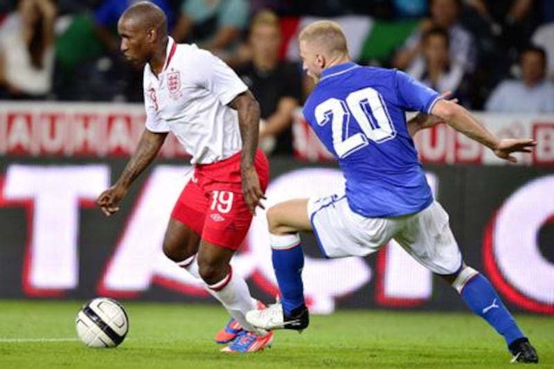 English forward Jermain Defoe (L) controls the ball prior to scoring his team's second goal next to Italian defender Ignazio Abate during a friendly football match between Italy and England on August 15, 2012 in the Swiss capital Bern.   AFP PHOTO / FABRICE COFFRINI

