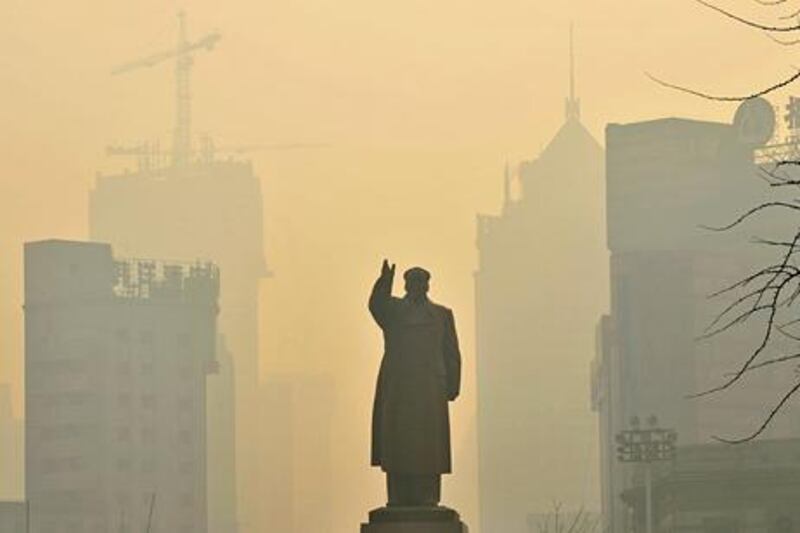A statue of China's late Chairman Mao Zedong is seen in front of buildings during a hazy day in Shenyang, Liaoning province, May 7, 2013. REUTERS/Stringer (CHINA - Tags: POLITICS ENVIRONMENT TPX IMAGES OF THE DAY) - RTXZD7A