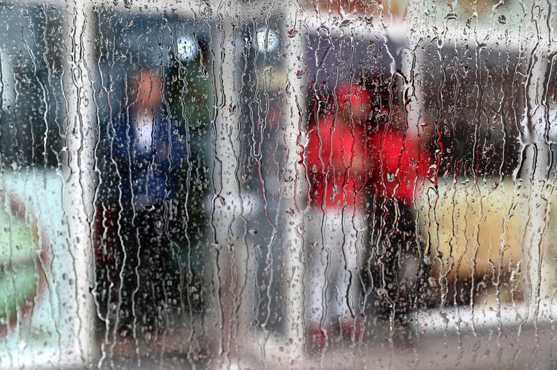 DUBAI, UNITED ARAB EMIRATES , March 22 – 2020 :- Shopkeepers outside their shops during the heavy rain in Al Barsha in Dubai. (Pawan Singh / The National) For News/Online/Instagram. 