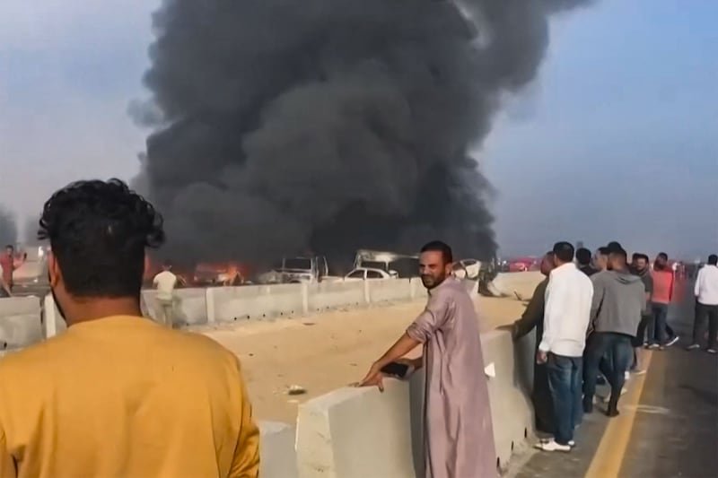 Black smoke billows from charred vehicles after a deadly pile-up on the Cairo-Alexandria motorway, near Wadi Al Natrun, in this still taken from a video posted on Facebook.  AFP