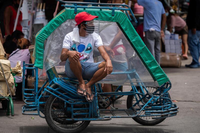 A rickshaw driver wears a face mask and a makeshift face shield made of a water bottle, following their mandatory use in all public transport services, amid the Covid-19 outbreak in Manila, Philippines. Reuters