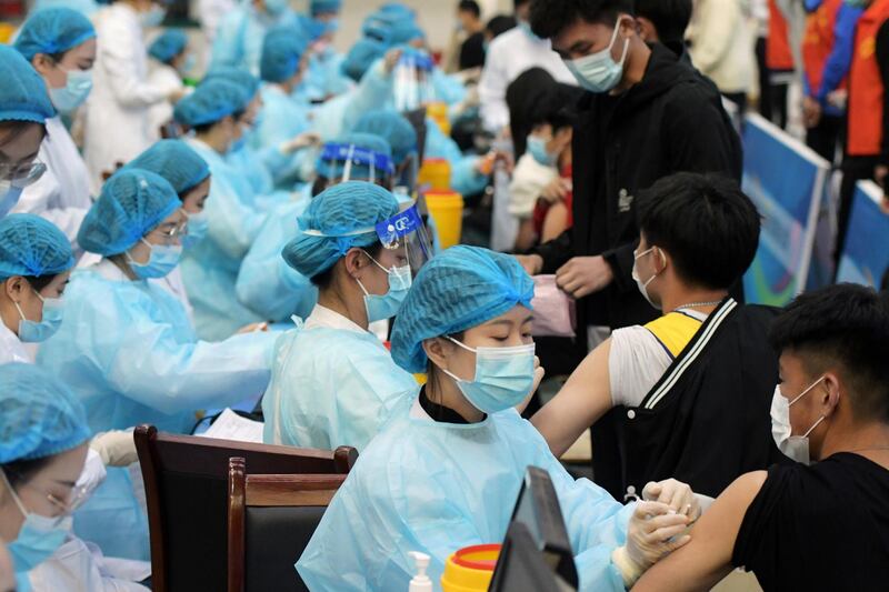 Medical workers inoculate students with the vaccine against Covid-19 at a university in Qingdao, Shandong province, China. Reuters
