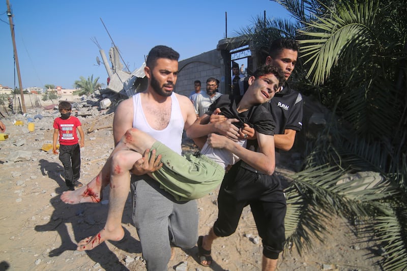 Palestinians evacuate a wounded youth after an Israeli airstrike in Rafah, Gaza Strip. AP