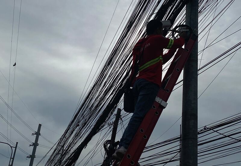 A lineman works on an electric post in Makati city, the Philippines. EPA