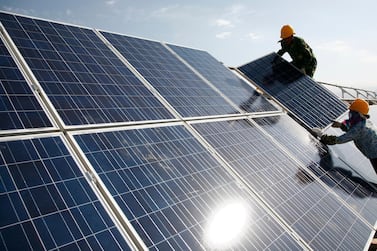 Workers install solar panels at a photovoltaic power station in Hami in northwestern China. The world's second-biggest economy installed 136 gigawatts of renewables capacity last year, 49 gigawatts of which was solar. AP Photo