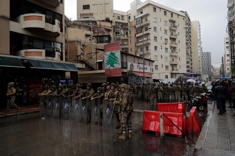 Lebanese security forces stand guard as anti-government protesters go around the homes of deputies and government officials in the northern port city of Tripoli. AFP