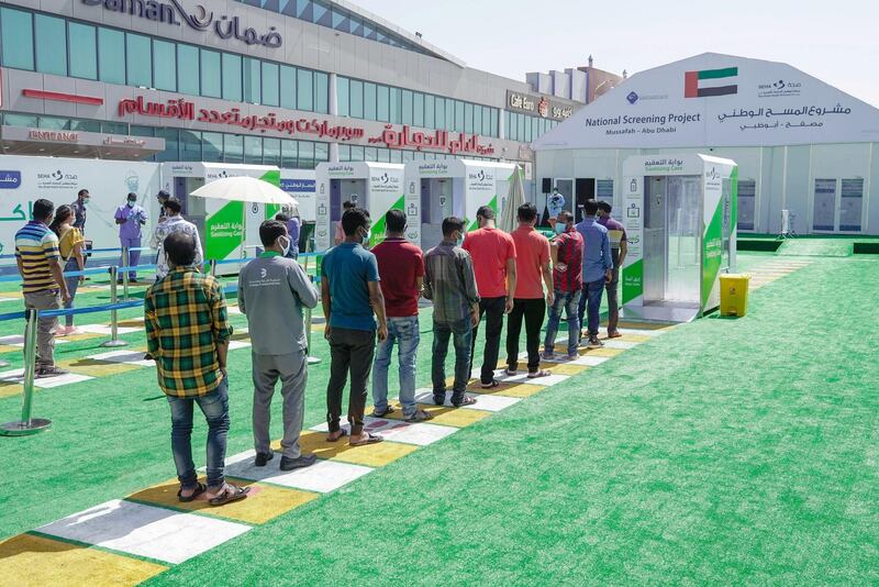 Abu Dhabi, United Arab Emirates, May 6, 2020. the new Ambulatory Healthcare Services, a SEHA Health System Facility, National Screening Project in Mussafah Industrial Area in Abu Dhabi.  -- Workers and residents queue infront of the Sanitising Gate before they can enter the main tent screening center.
Victor Besa / The National
Section:  NA
Reporter:  Nick Webster