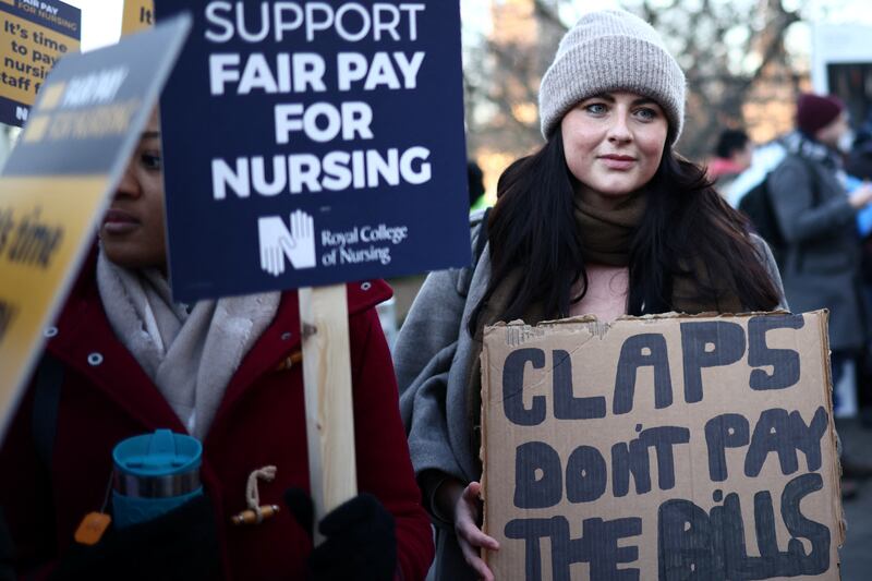 A sign, right, referring to the Clap for our Carers campaign during the Covid-19 pandemic. Many nurses say they would rather be rewarded with a pay rise. Reuters