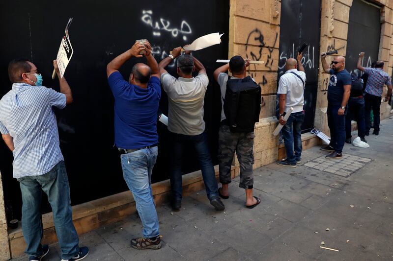 Bank customers bang on the metal shutter of a bank during a protest in Beirut, Lebanon. AP Photo