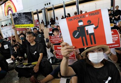Demonstrators raise placards during a protest at Hong Kong International Airport, Friday, July 26, 2019. Hong Kong residents have been protesting for more than a month to call for democratic reforms and the withdrawal of a controversial extradition bill. Their five central demands include direct elections, the dissolution of the current legislature, and an investigation into alleged police brutality. Clashes between protesters and police and other parties have become increasingly violent. (AP Photo/Vincent Yu)