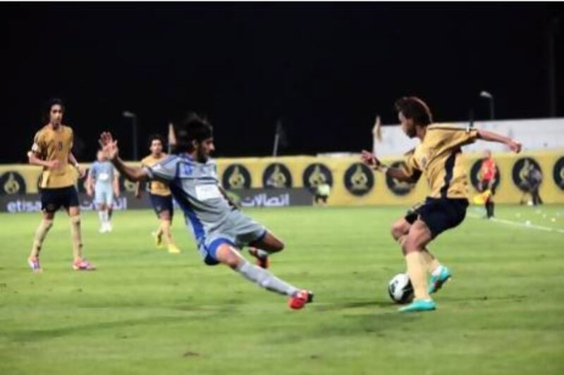 Humaid Abbas, No 8, trying to tackle Dubai's Waleed Khaleed, was one of four goal scorers for Al Nasr during their Etisalat Cup match tonight. Jeffrey E Biteng / The National