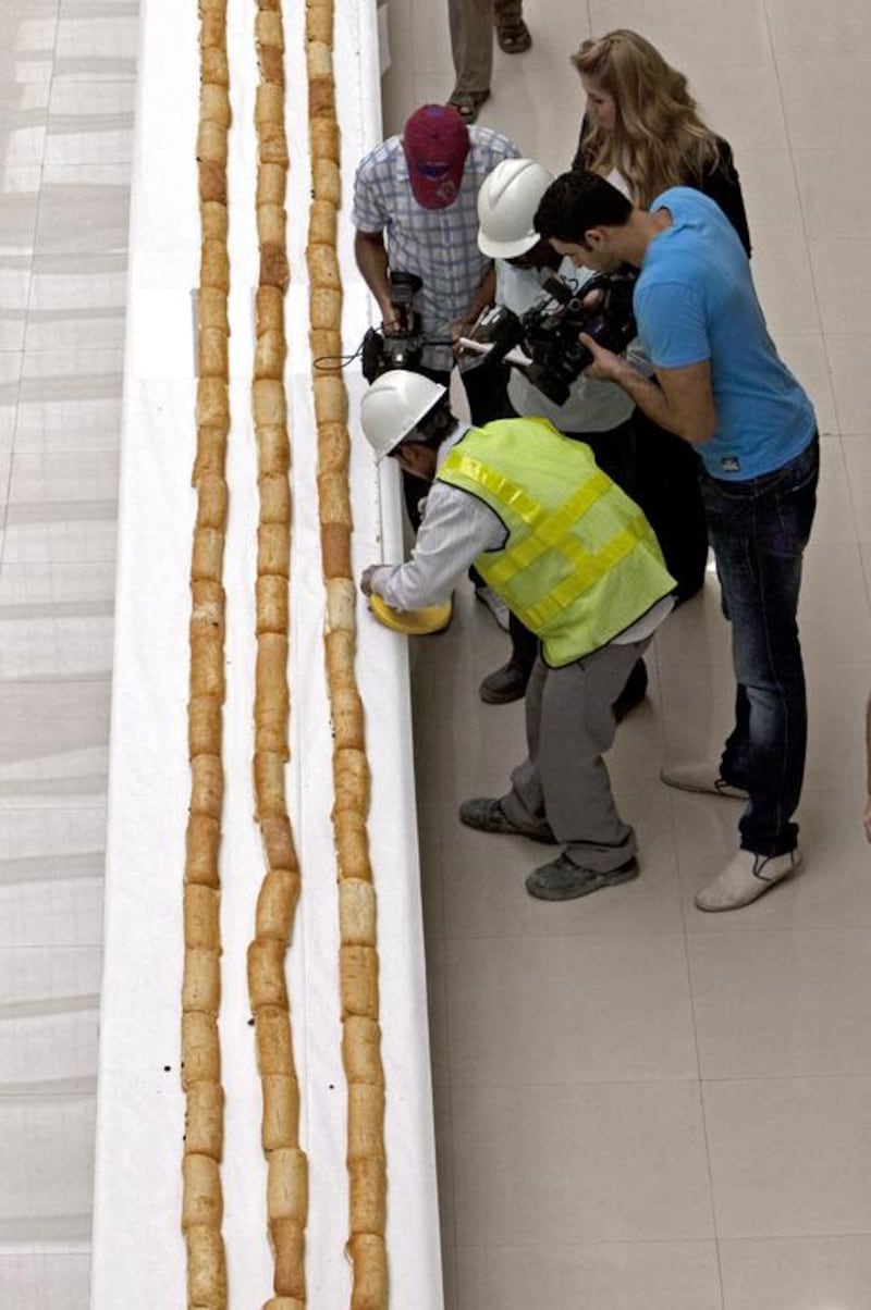 Surveyors from Falcon Survey Engineering Consultancy measure what be verified as the world’s longest sandwich made at Dubai Outlet Mall in Dubai, October 7, 2010. Liz Smith of Guinness World Records oversaw the measuring of the sandwich and verified its’ length at 2,667.13 meters. The sandwich sections will be distributed to labourers in three different camps and some families in Dubai. Jeff Topping / The National) 