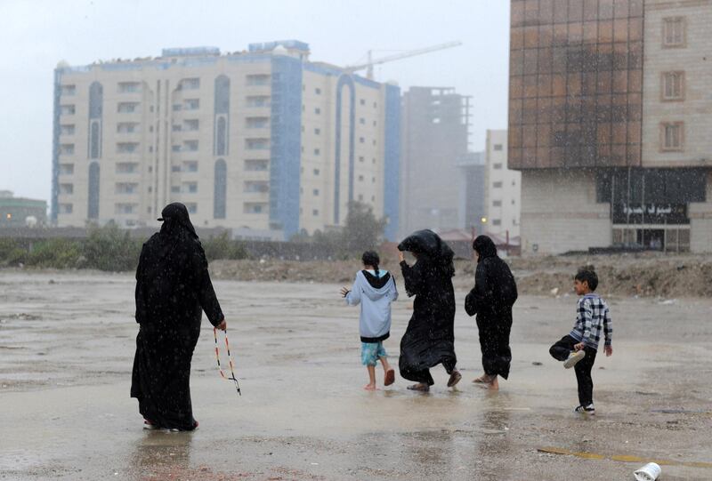 Saudi women and children stand in a flooded street in Jeddah on November 21, 2017. 
Flash floods triggered by heavy rains swept through Jeddah, leaving motorists stranded and forcing authorities to shut schools and universities in Saudi Arabia's second biggest city. Dozens of people were plucked from vehicles engulfed by floodwaters, Saudi civil defence authorities said, with heavy rainfall expected to last at least until Wednesday.
 / AFP PHOTO / Amer HILABI