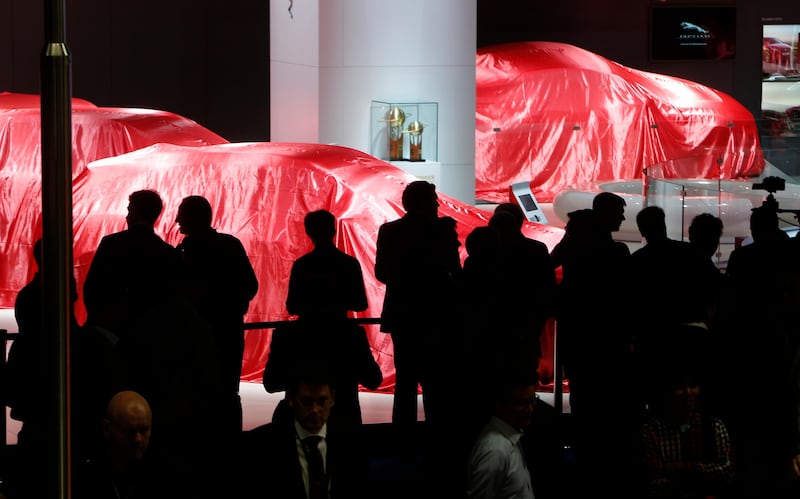 Visitors wait for Ferrari to reveal their latest models at Frankfurt. Michael Probst / AP Photo