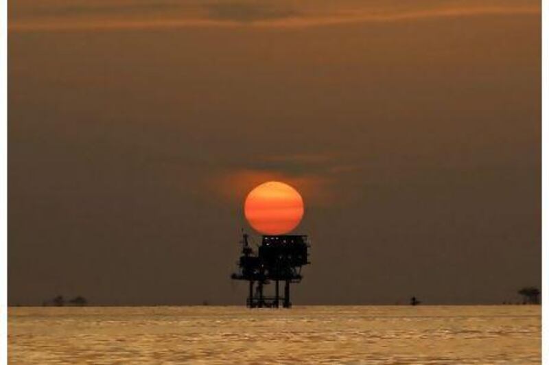 An offshore oil platform and wells are silhouetted by the setting sun in the Gulf of Mexico off the coast of Louisiana, U.S., on Thursday, July 15, 2010. BP Plc said that a pressure test on its damaged Macondo well halted the flow of oil into the Gulf for the first time in three months. The BP Plc Deepwater Horizon oil spill, the biggest in U.S. history, had been spewing 35,000 to 60,000 barrels of oil a day since the drilling rig exploded on April 20. Photographer: Derick E. Hingle/Bloomberg