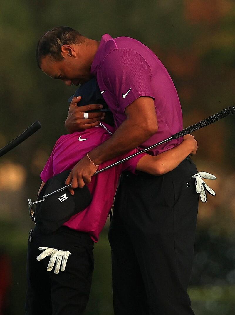 Tiger Woods hugs son Charlie on the 18th hole. AFP