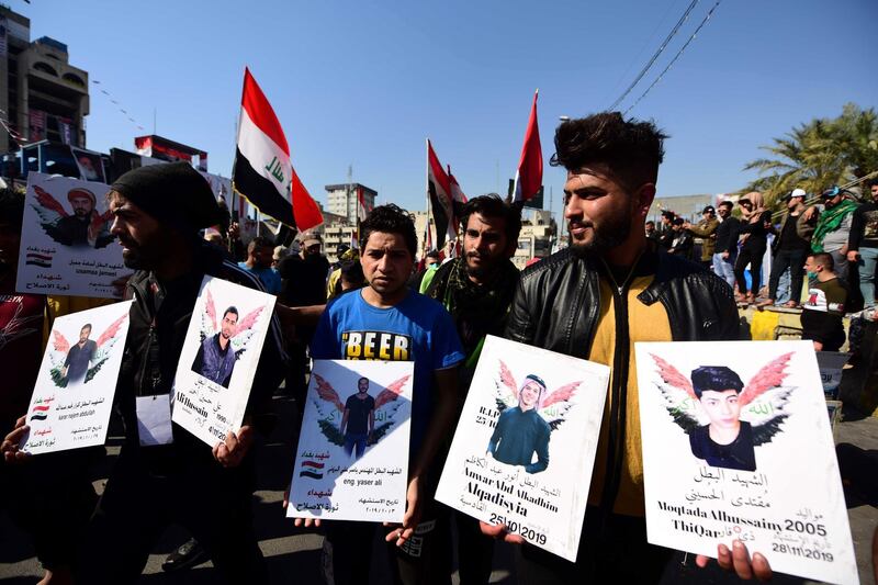 Iraqi university students hold photos of protesters allegedly killed in the continuing unrest during a protest in central Baghdad, Iraq.  EPA