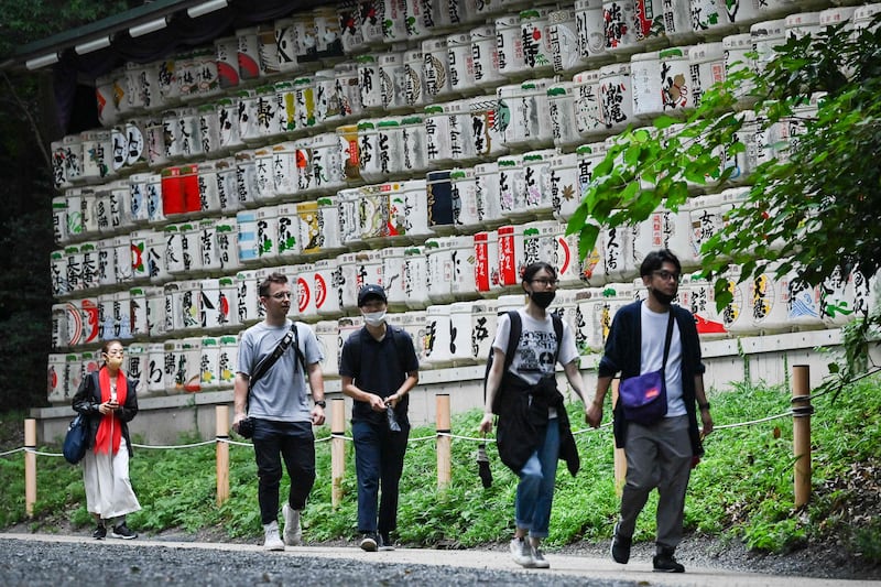 Tourists walk at the Meiji Shrine in Tokyo. AFP