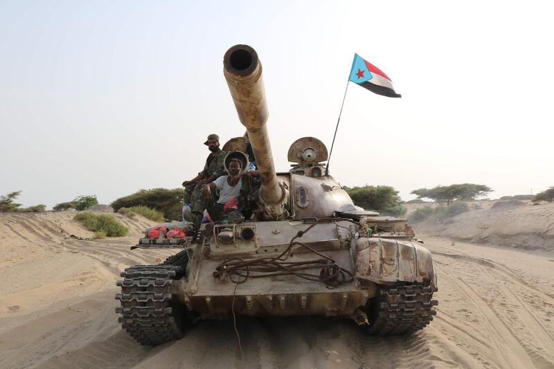 TOPSHOT - Fighters of the UAE-trained Security Belt Force, dominated by fighters of the the Southern Transitional Council (STC) which seeks independence for south Yemen, ride atop a tank in Yemen's southern coastal town of Shuqrah on August 27, 2019. Saudi Arabia and the United Arab Emirates renewed a call earlier this week for peace talks between Yemen's government and southern separatists, urging a ceasefire following deadly clashes. / AFP / -
