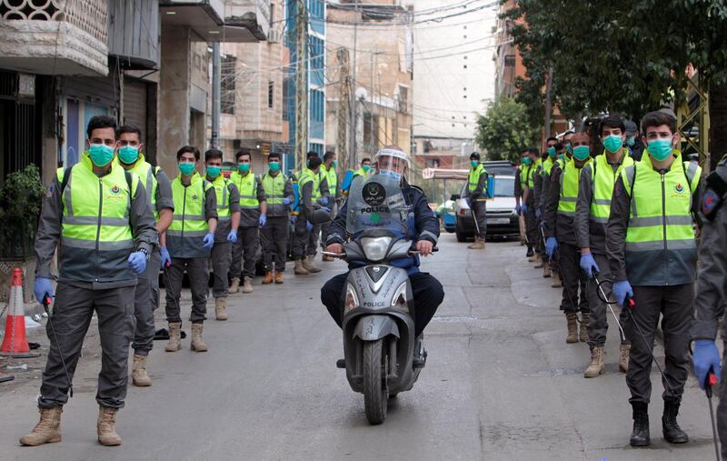 Volunteers from Hezbollah's Islamic health unit stand in preparation to sanitize streets as precaution against the spread of coronavirus disease (COVID-19), during a media tour organised by Hezbollah officials in Beirut's southern suburb, Lebanon March 31, 2020. Picture taken March 31, 2020. REUTERS/Aziz Taher