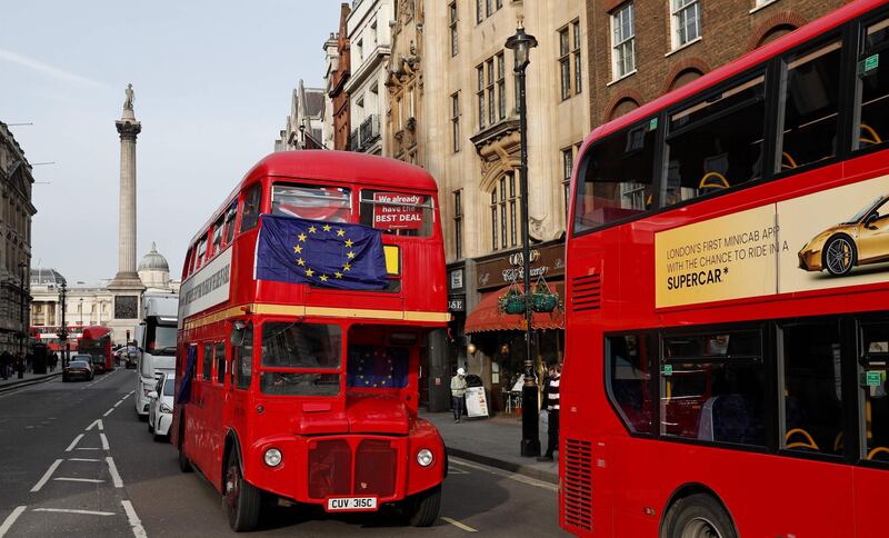 TOPSHOT - Anti-Brexit activists travel on an old red London Routemaster bus, with EU flags in its windows, as they drive around Westminsters in London on January 29, 2019. British Prime Minister Theresa May heads into her latest Brexit battle on Tuesday weakened but still determined to get her legacy-defining deal through parliament, as MPs wrestle to take control of the process. / AFP / Adrian DENNIS
