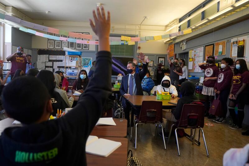 Gavin Newsom, middle, speaks to students in a seventh grade science class at James Denman Middle School in San Francisco. AP Photo