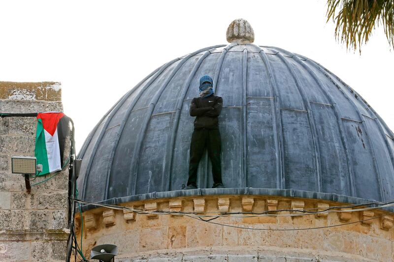 A Palestinian protester stands atop Al Aqsa Mosque in Jerusalem, hours before a planned march to commemorate Israel's takeover of Jerusalem in the 1967 Arab-Israeli War. AFP