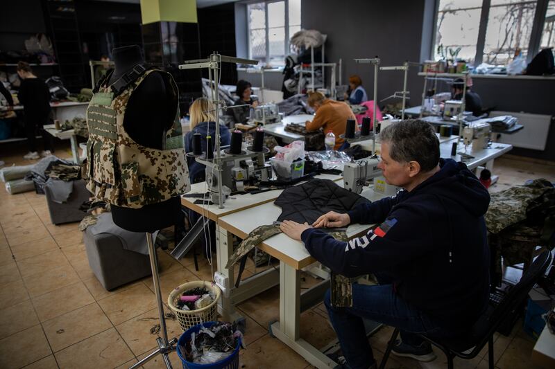 A worker measures fabric as part of the process, in which men and women work from 7am to 7pm, seven days a week.