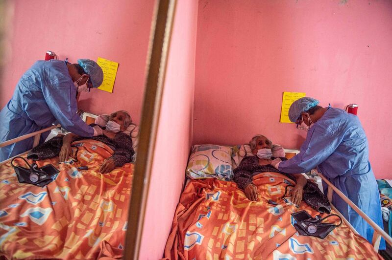 A health worker gives Maria Tafur the Pfizer-BioNTech vaccine at her home in Lima's El Agustino district. AFP