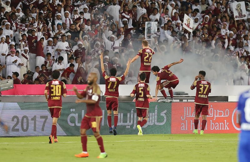 Al Wahda players celebrate in front of their fans after scoring the opening goal.