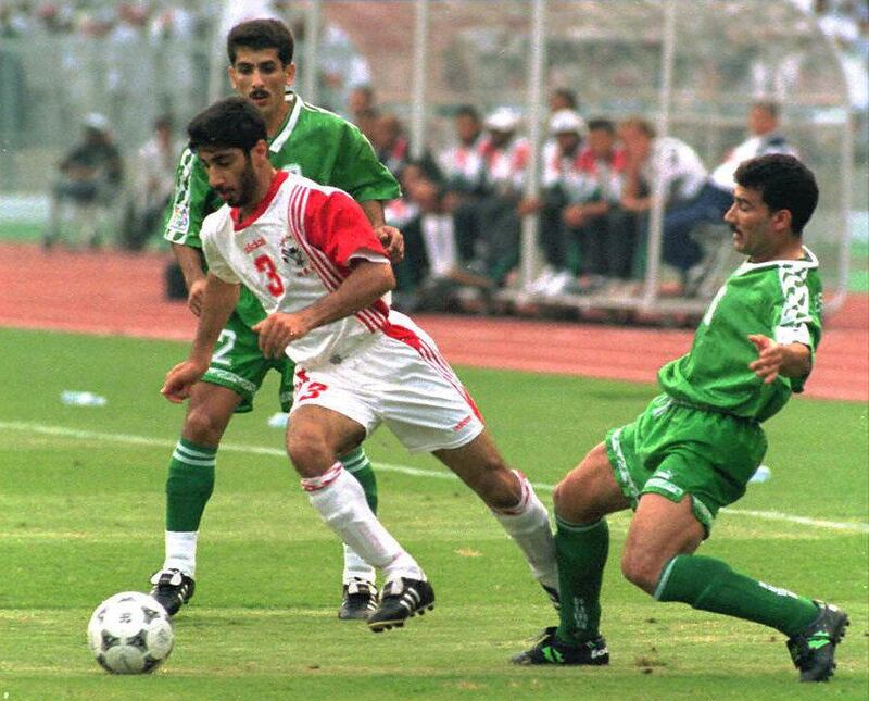 UAE's Munther Abdulla (C) dribbles past Iraqi defenders Hayder Majeed (L) and Esam Salem 15 December during their Asian Cup quarterfinal match in Abu Dhabi. (Photo by JORGE FERRARI / AFP)