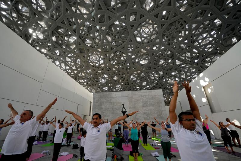 Indian Ambassador to UAE, Sunjay Sudhir, performs yoga with others to mark the 9th International Day of Yoga at the Louvre Museum in Abu Dhabi. AP