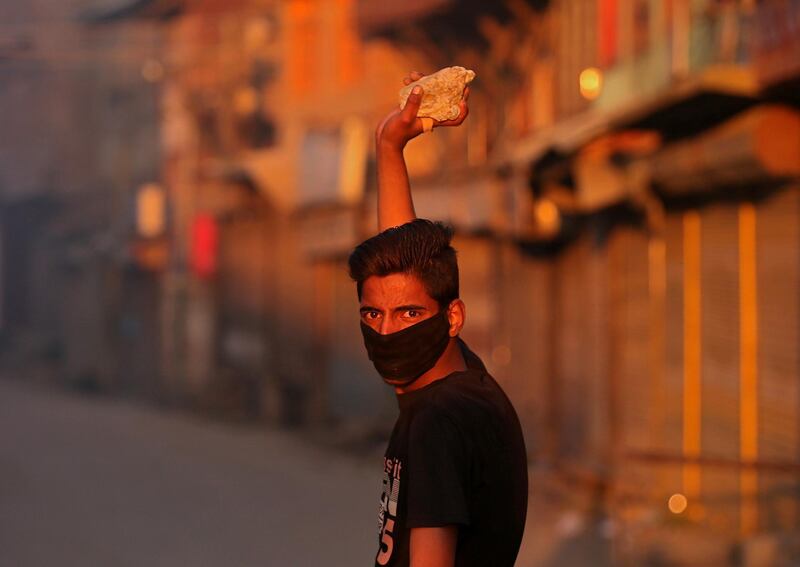 A masked Kashmiri demonstrator looks on as he prepares to throw a stone towards Indian police during a protest after the end of the second phase of general election in Srinagar April 18, 2019. REUTERS/Danish Ismail