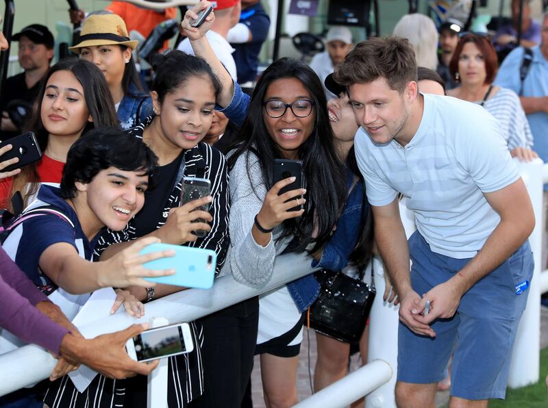 Niall Horan poses for selfies with fans during the pro-am at Emirates Golf Club. David Cannon / Getty Images